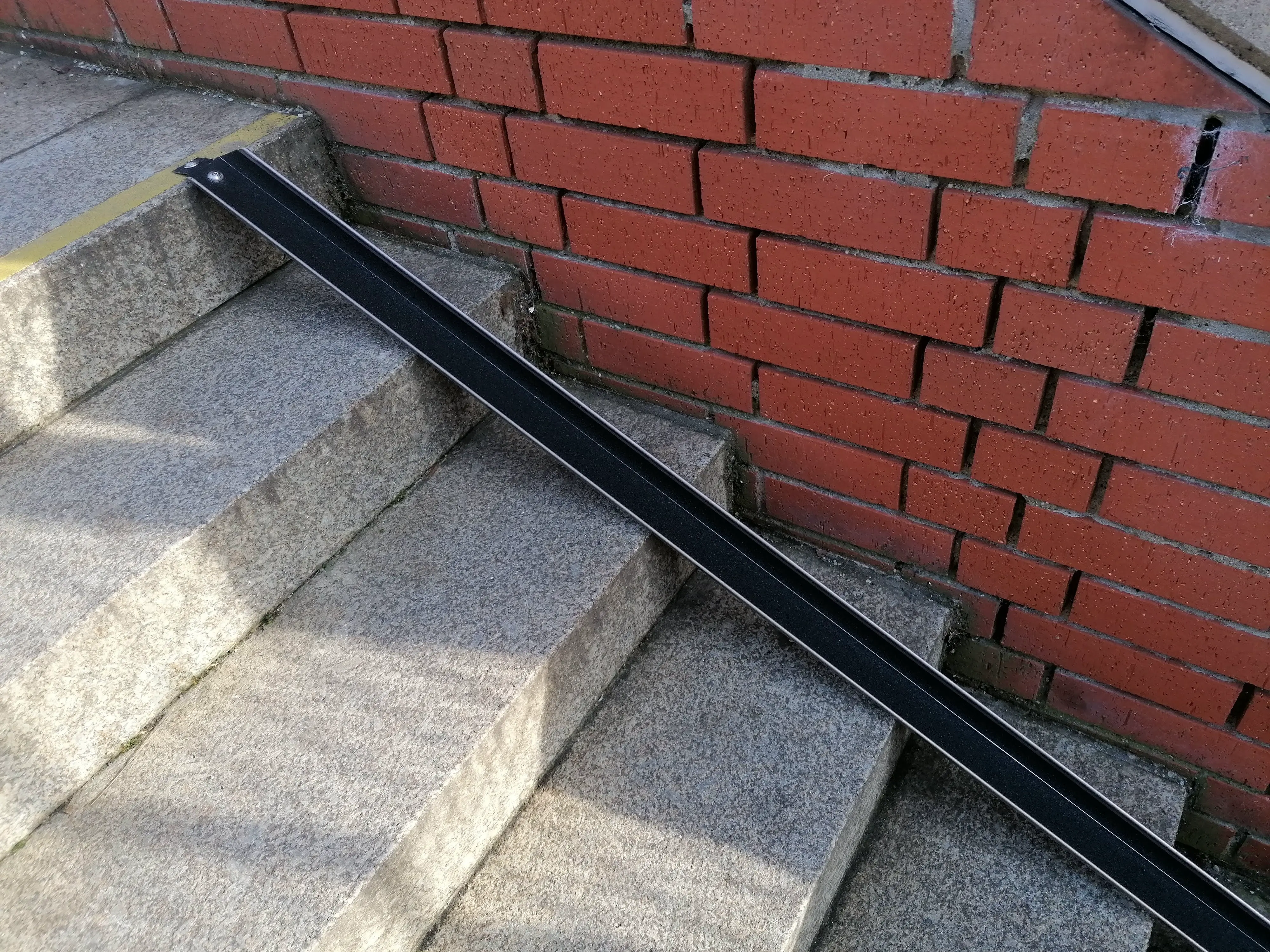 Fahrradschiene Slim an einer Steintreppe im Außenbereich